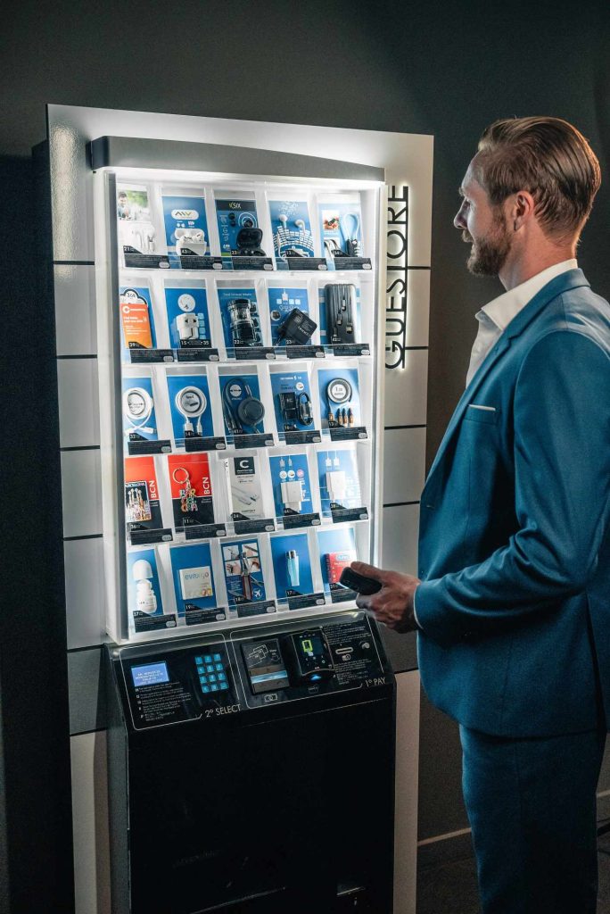 Boutique inteligente personalizada con accesorios móviles en el lobby de un hotel de Barcelona. Diseño compacto y elegante.